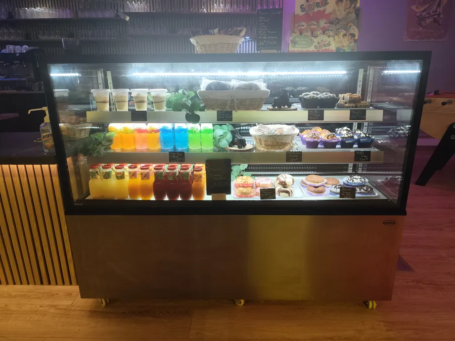 Vitrine snack La Piste — donuts, jus et pâtisseries.